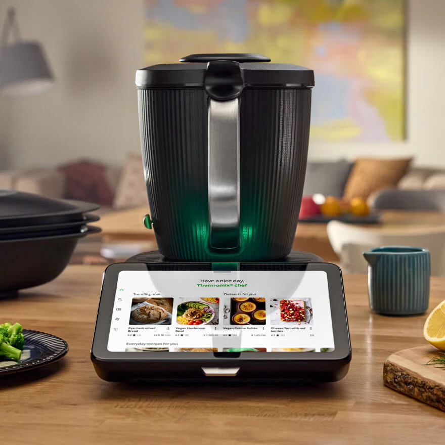 Smart kitchen appliance with digital display on a wooden table in a home setting